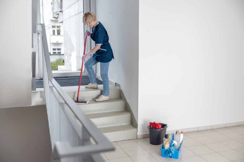 cleaning-lady-uniform-with-mop-rag-washes-dusty-steps-house